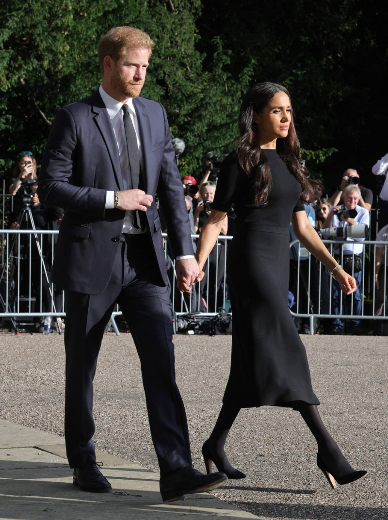 Meghan, Duchess of Sussex, Prince Harry, Duke of Sussex, Prince William, Prince of Wales and Catherine, Princess of Wales look at floral tributes laid by members of the public on the Long walk at Windsor Castle
