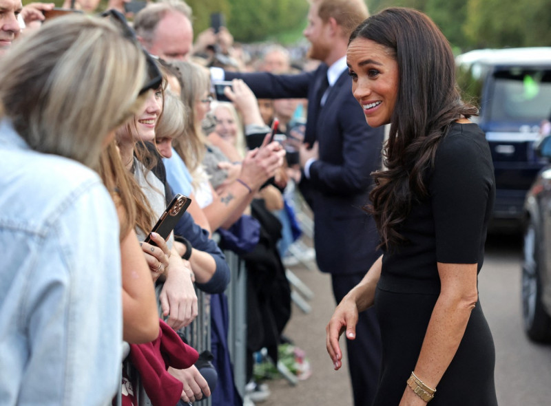 Meghan, Duchess of Sussex, Prince Harry, Duke of Sussex, Prince William, Prince of Wales and Catherine, Princess of Wales look at floral tributes laid by members of the public on the Long walk at Windsor Castle