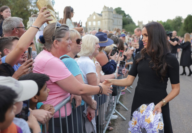 Meghan, Duchess of Sussex, Prince Harry, Duke of Sussex, Prince William, Prince of Wales and Catherine, Princess of Wales look at floral tributes laid by members of the public on the Long walk at Windsor Castle