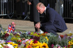 Meghan, Duchess of Sussex, Prince Harry, Duke of Sussex, Prince William, Prince of Wales and Catherine, Princess of Wales look at floral tributes laid by members of the public on the Long walk at Windsor Castle