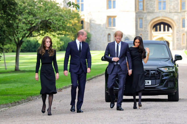 Meghan, Duchess of Sussex, Prince Harry, Duke of Sussex, Prince William, Prince of Wales and Catherine, Princess of Wales look at floral tributes laid by members of the public on the Long walk at Windsor Castle