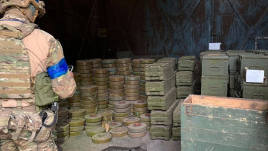 militar ucrainean inspectează un depozit de muniții abandonat de armata rusă în retragere, zona Izium