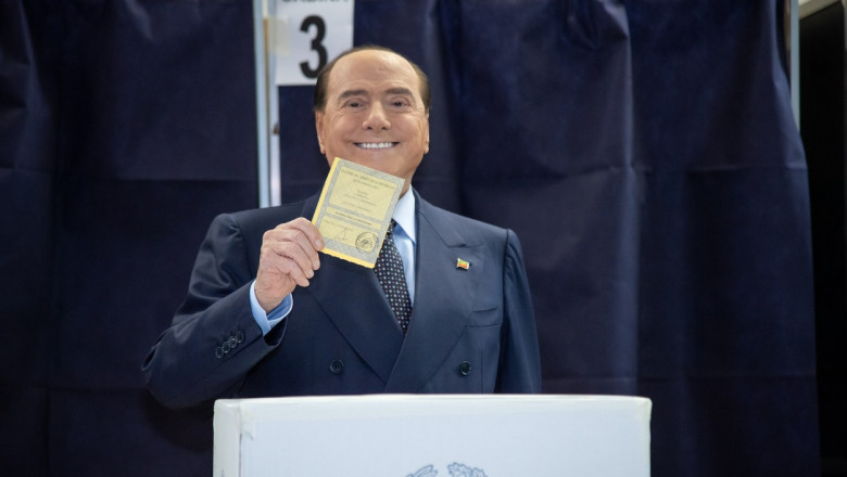 Silvio Berlusconi cu un buletin de vot în mână în fața unei urne de vot