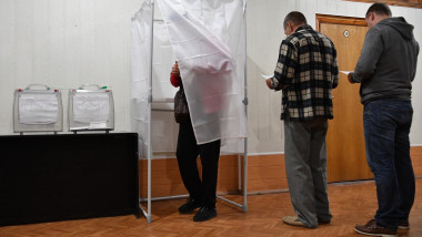 Residents queue to a voting booth during a referendum on joining Russia at a polling station in Melitopol, Zaporizhzhia region