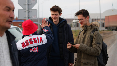 Russians are welcomed by a volunteer upon arrival in Kazakhstan crossing the Syrym border crossing point on September 27, 2022