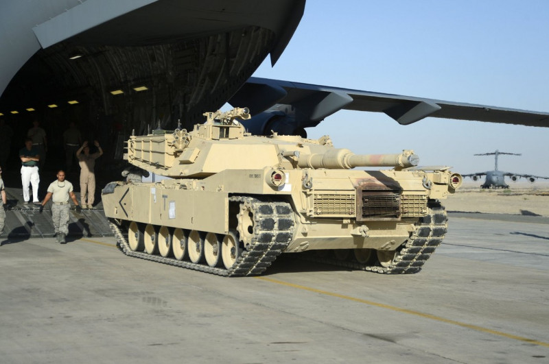 Members of the 386th Air Expeditionary Wing monitor the offload of a M1 Abrams tank from a C-17 Globemaster III here, Sept. 26,
