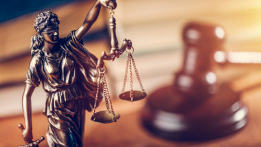 Statuetă reprezentând Justiția lângă un ciocanel de judecător.