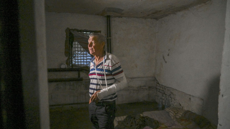Om bătrân cu mâna bandajată într-o celulă insalubră