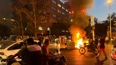 scene de la un protest cu un obiect incendiat ]n mijlocul unei străzi