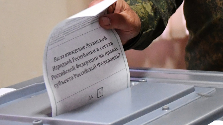 A service member of LPR militia casts his ballot during the referendum on the republic to become integral part of Russia
