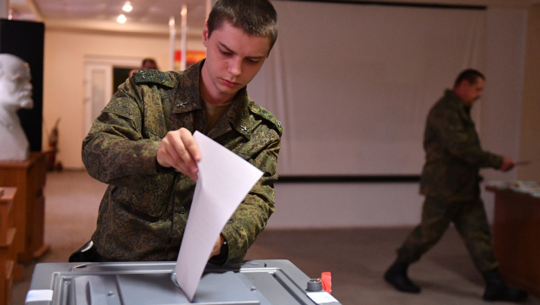 Service members of LPR militia vote during the referendum on the republic to become integral part of Russia at a polling station in Luhansk