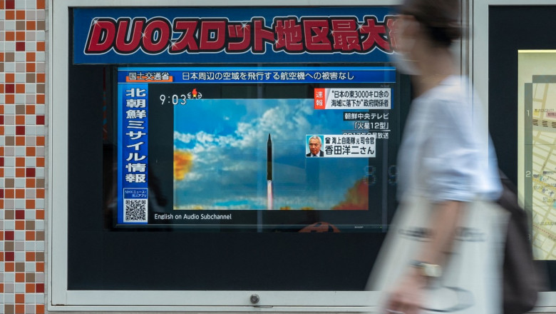 o femeie priveste spre un ecran unde se anunta ca coreea de nord a lansat o racheta balistica