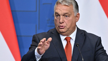 Viktor Orban gesticulează la un podium cu un microfon în față