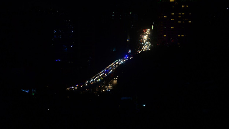 bulevard din bangladesh iluminat de farurile masinilor in timpul unei pene de curent