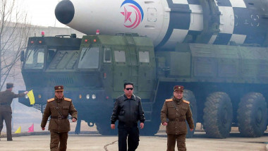 kim jong un langa lideri militari avand in spate un camion cu o racheta balistica