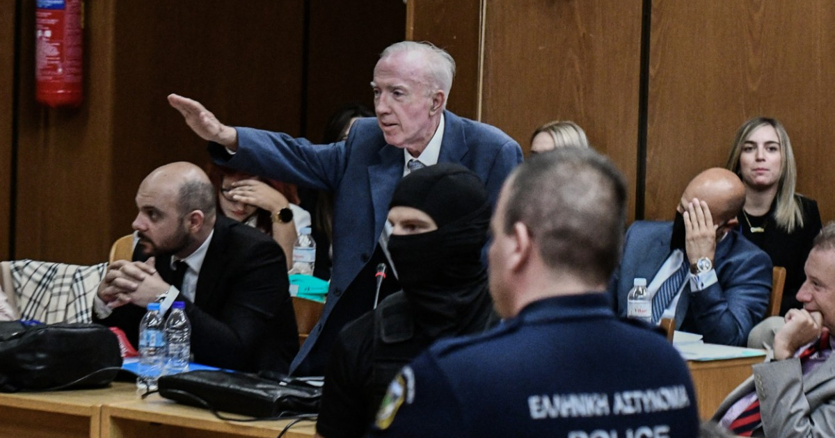Δικηγόρος εξτρεμιστών της Χρυσής Αυγής της Ελλάδας, πατέρας υπουργού, σηκώνει το χέρι για ναζιστικό χαιρετισμό κατά τη διάρκεια της δίκης