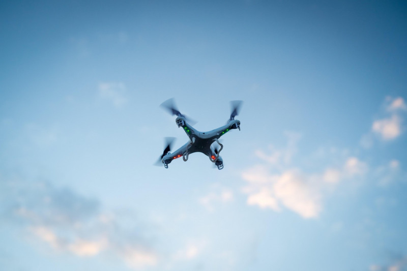 A man flies a quadcopter, or drone, in a park in Oxford, UK