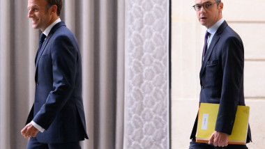 Președintele Franței și colaboratorul său, Alexis Kohler, în spate, cu un dosar galben în mână