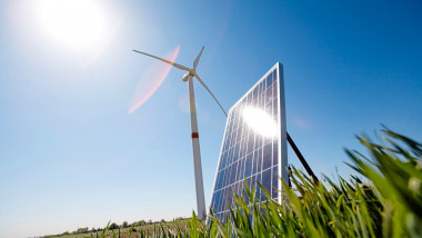 stalp de energie eoliana langa un panou fotovoltaic