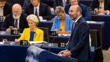 manfred weber vorbeste de la pupitru in parlamentul european iar pe fundal este ursula von der leyen, frans timmermans