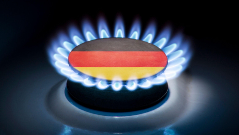 Burning gas burner of a home stove in the middle of which is the flag of the country of Germany. Gas import and export delivery concept, price per cub