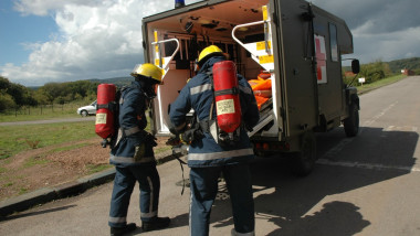 personal medical echipat anti-radiatii langa o ambulanta militara