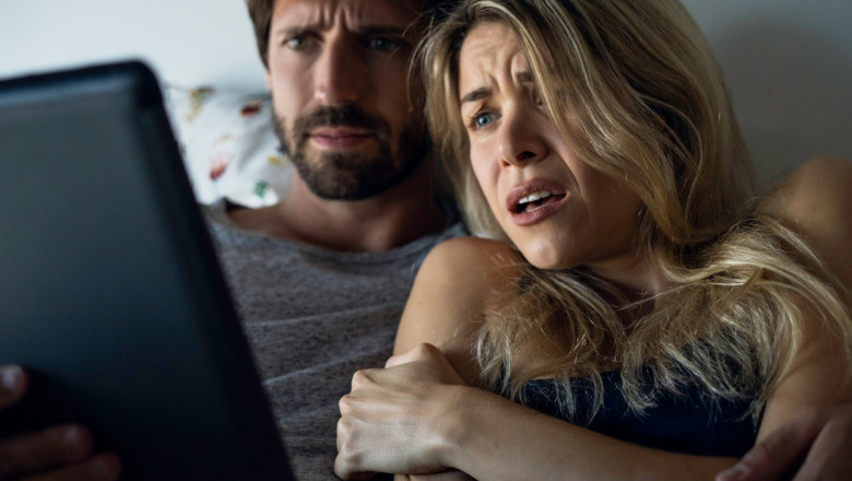 cuplu care se uita la un film de groaza pe tableta