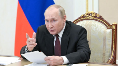 vladimit putin gesticuleaza la birou, cu hartii in mana