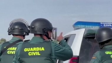 Ofițer Guardia Civil din Spania, lângă o mașină de intervenție
