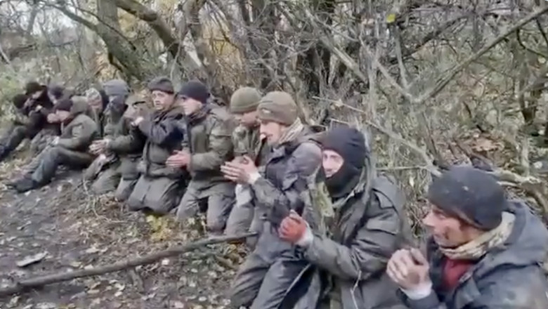 prizonieri rusi in genunchi, cu mainile legate