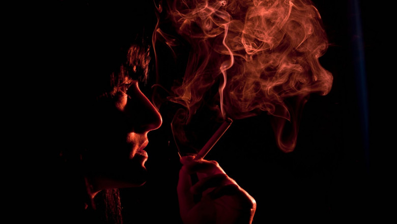 o femeie care fumeaza in intuneric