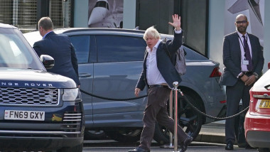 Boris Johnsonn face cu mâna printre mașini