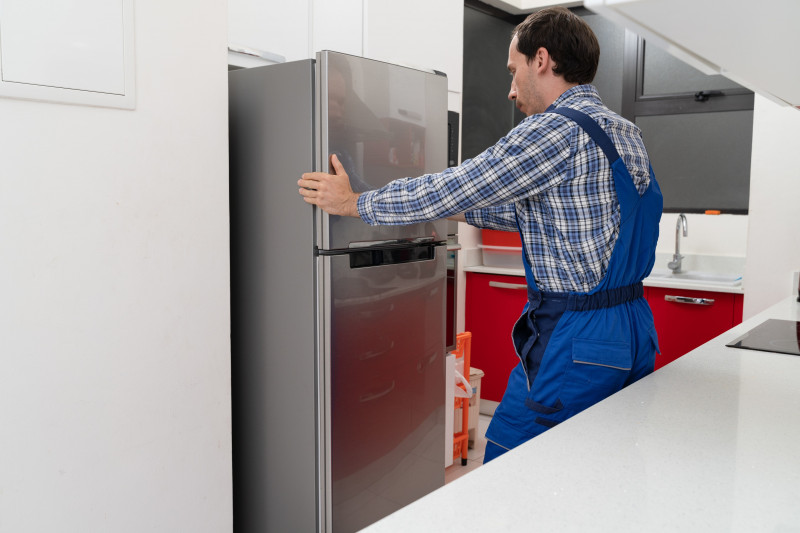 Mover Placing Refrigerator In Kitchen
