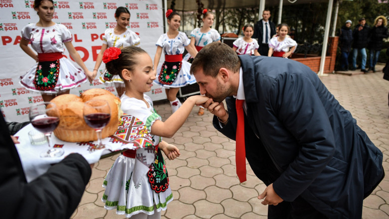 Moldova's parliamentary candidate Ilan Shor, businessman, leader of his self-named party and the mayor of the town of Orhei, is welcomed by girls wearing traditional outfits while arriving to meet with supporters during a campaign event in the city of Comrat on February 15, 2019.