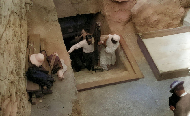 Howard Carter and an Egyptian worker remove a fragment of the deathbed from Tutankhamuns tomb in 1923