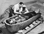 Howard Carter examining the sarcophagus from the tomb of King Tutankhamun, Luxor, Egypt. Photo taken in 1922