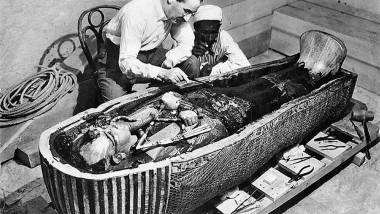 Howard Carter examining the sarcophagus from the tomb of King Tutankhamun, Luxor, Egypt. Photo taken in 1922
