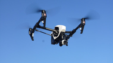 drona alb cu negru in zbor