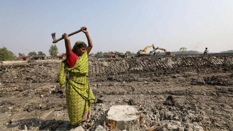 Khulna, Bangladesh: A woman collects wood at the ongoing development project near the Sundarbans mangrove forest, the world heritage site, in Khulna, Bangladesh. People's lives getting worse every day due to the climate change effect. Most of the people d