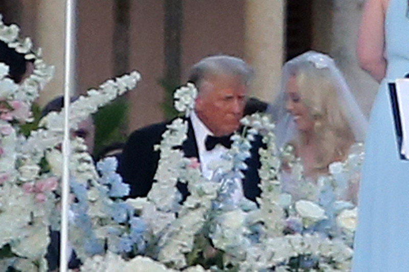 Donald Trump walks daughter Tiffany Trump down the aisle as Ivanka Trump follows behind and helps with her sisters dress as she marries Michael Boulos at Mar-A-Lago