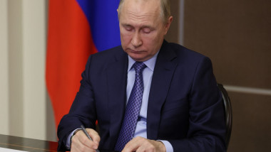 Putin semnează niște acte.