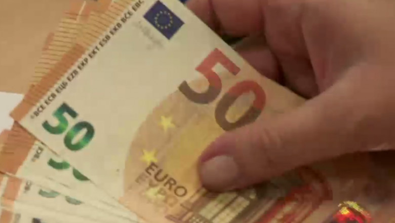 O femeie numără bancnote de euro