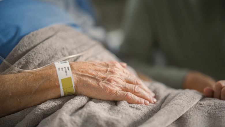 Wife visiting elderly man on hospital ward