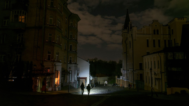 cladiri intuneric pana de curent la kiev, doi oameni pe strada cu lanterna