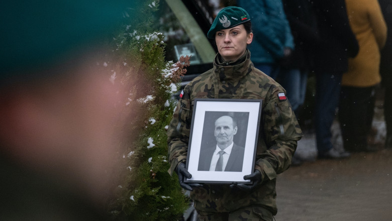 A Polish soldier carries a picture of one of two victims of a missile that hit a southeastern Polish village near the border with Ukraine, during his funeral in Przewodow