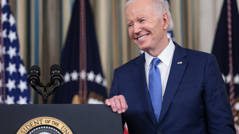 Joe Biden zâmbește larg la pupitrul prezidențial