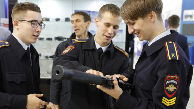 studenți ruși admiră o armă de asalt AK-101 la o expoziție de armament din Rusia