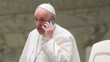 Papa Francisc vorbește la telefonul mobil.