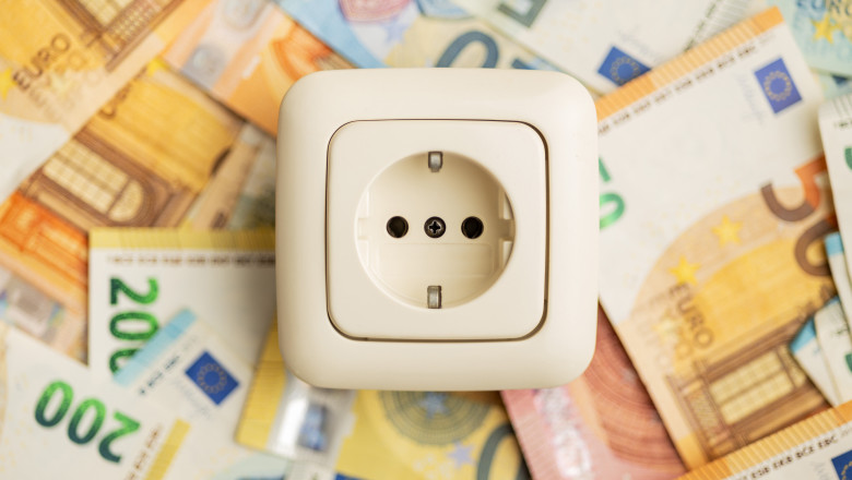 Electric wall socket and euro money. Concept of increasing electricity prices.