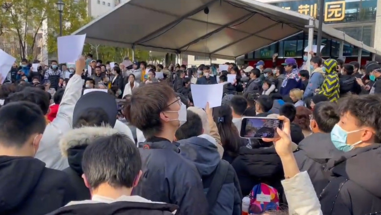 studenti protesteaza in fata unei universitati din chian, cu foi albe de hartie